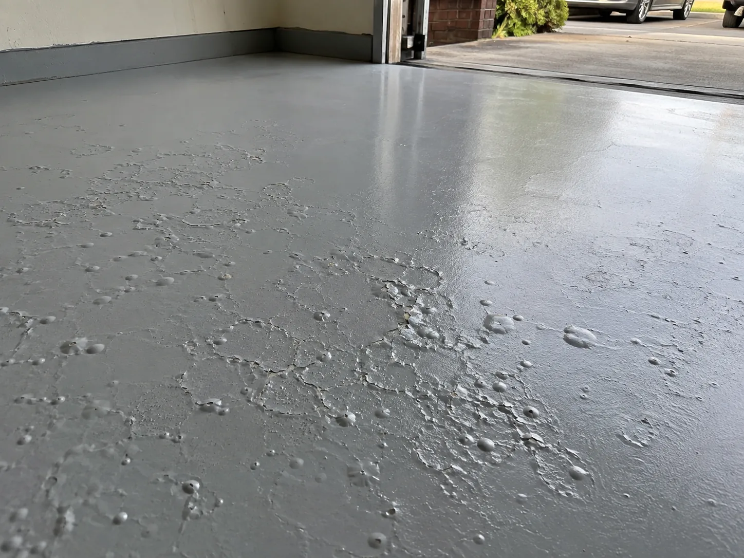 Grey epoxy floor covered in round moisture blisters